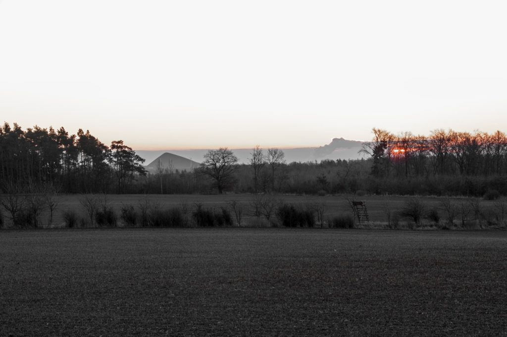 Bild: Die Pyramide des Thälmannschachtes an einem Wintermorgen. NIKON D90 mit AF-S DX NIKKOR 18-200 mm 1:3.5-5.6G ED VR Ⅱ. Schwarz-Weiss mit Rottönen.