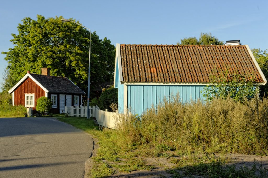 Bild: In Småland findet man auch die typischen rot oder blau angestrichenen Holzhäuser, so wie hier bei Hagby südlich von Kalmar. NIKON D700 und AF-S NIKKOR 24-120 mm 1:4G ED VR.