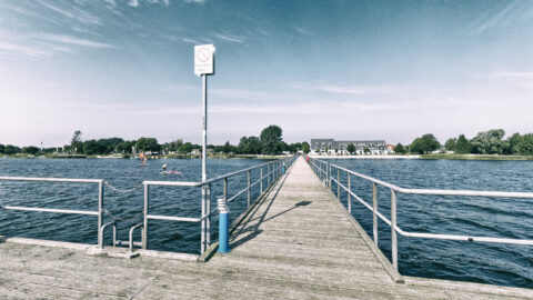 Bild: Blick von der Seebrücke Dranske auf der Insel Rügen auf den Ort. Foto: Copyright (c) 2020 by Birk Karsten Ecke. OLYMPUS OM-D EM-1 MkII mit M.ZUIKO DIGITAL ED 7‑14mm 1:2.8 PRO, ISO200, f/7.1, 1/640s, 7 mm. Klicken Sie auf das Bild um es zu vergrößern.