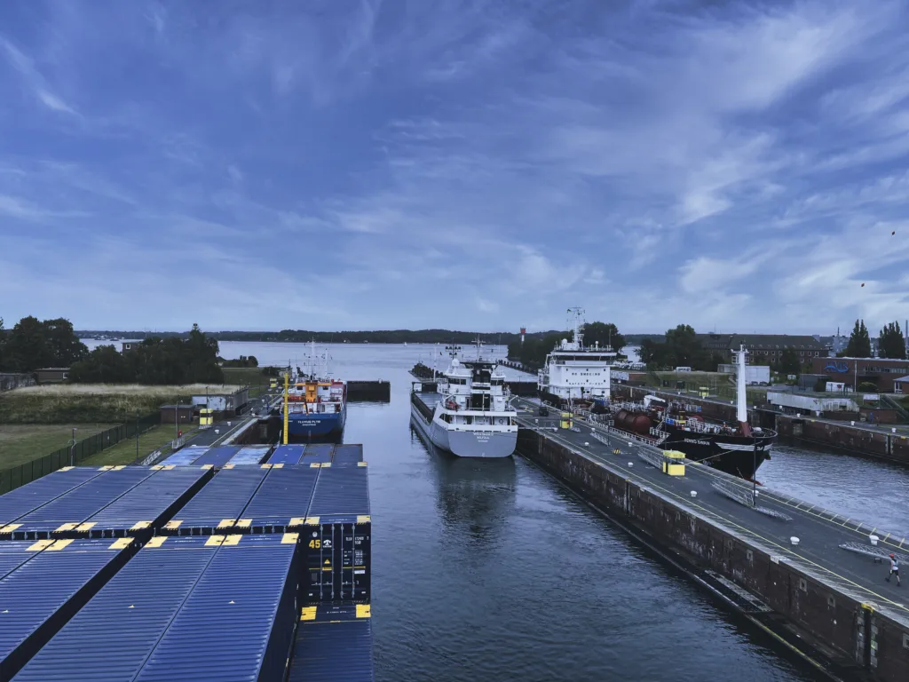 Bild: Ausfahrt des Frachtschiffes MS FREJ im Konvoi aus der Schleuse Kiel ind die Kieler Förde mit dem Ziel offene Ostsee. Klicken Sie auf das Bild um es zu vergrößern.